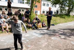 Klassen tegner katte med kridt i skolegården